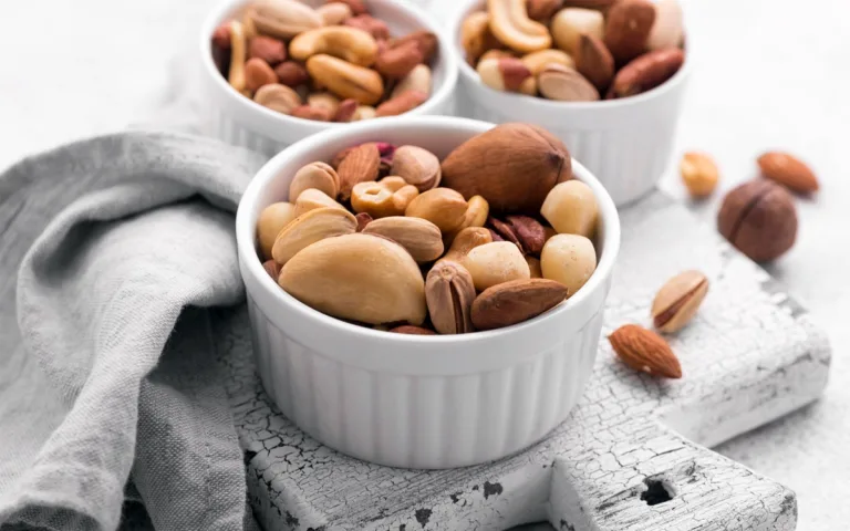 Various nuts arranged in white bowls on a white background, emphasizing their health benefits and natural goodness.