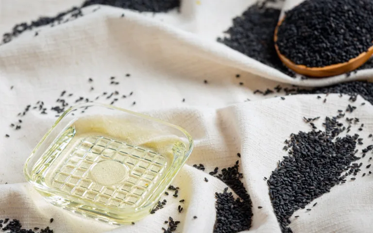 An image featuring black sesame seeds and a glass of oil, emphasizing their benefits for skin, weight, and overall health.