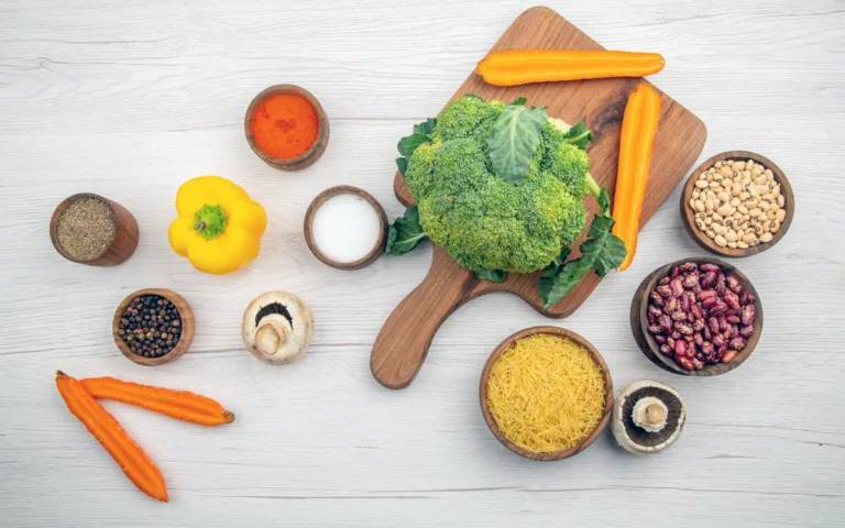 Fresh vegetables and beans are artfully placed on a wooden cutting board, showcasing essential nutrients for a balanced diet.