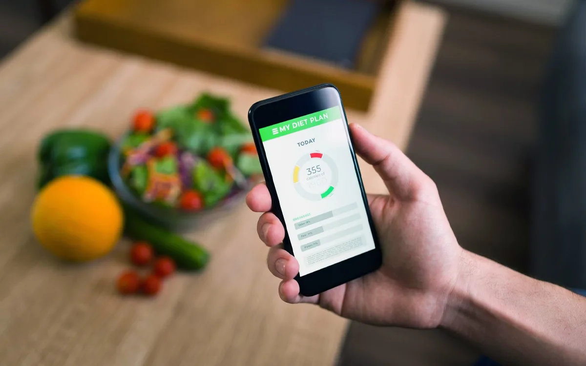 Individual holding a smartphone with a healthy food app, promoting mindful eating and the benefits of nutrient-rich foods.