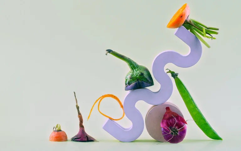 A colorful sculpture composed of various vegetables and flowers, blending artistry with organic materials.