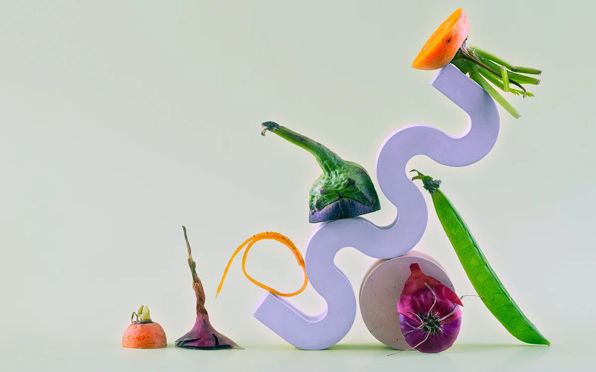 A colorful sculpture composed of various vegetables and flowers, blending artistry with organic materials.