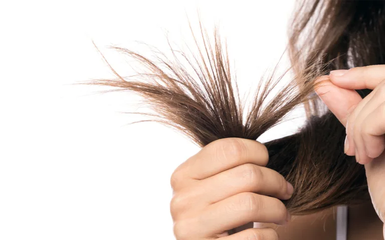 A woman combs her hair, focusing on maintaining healthy strands and preventing split ends.