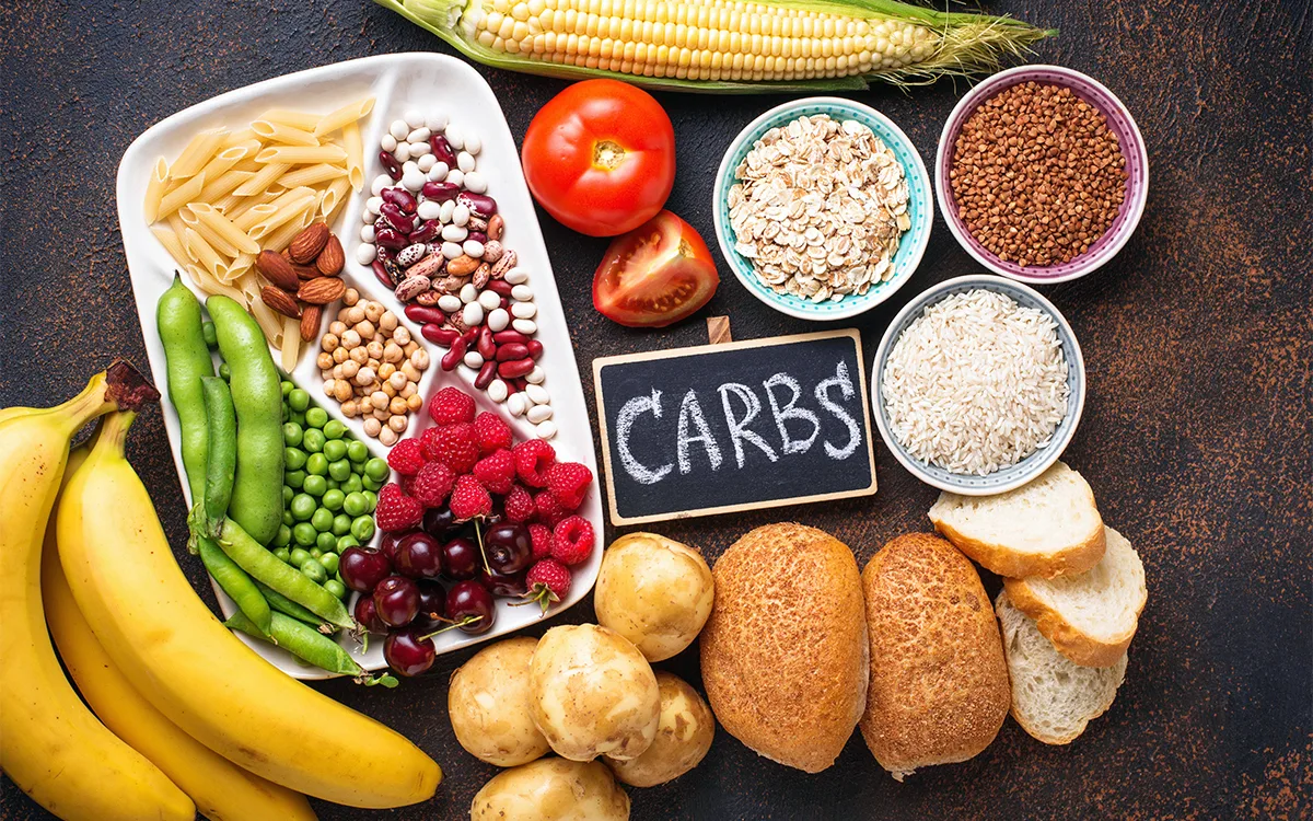 A table displays an assortment of carbohydrates, fruits, vegetables, and grains, highlighting healthy nutrition for endurance athletes.