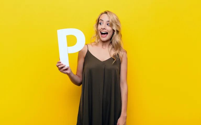 A woman holds a letter "P" against a bright yellow background, symbolizing the concept of pleasure in healthy eating.