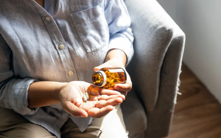 A woman holding a bottle of medicine, symbolizing the importance of supplements for health and wellness.