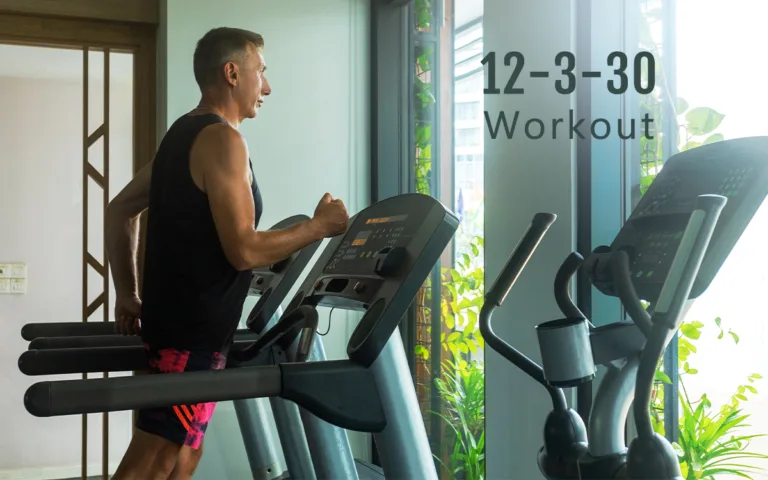A man runs on a treadmill in a gym, demonstrating the popular 12-3-30 workout routine for fitness enthusiasts.