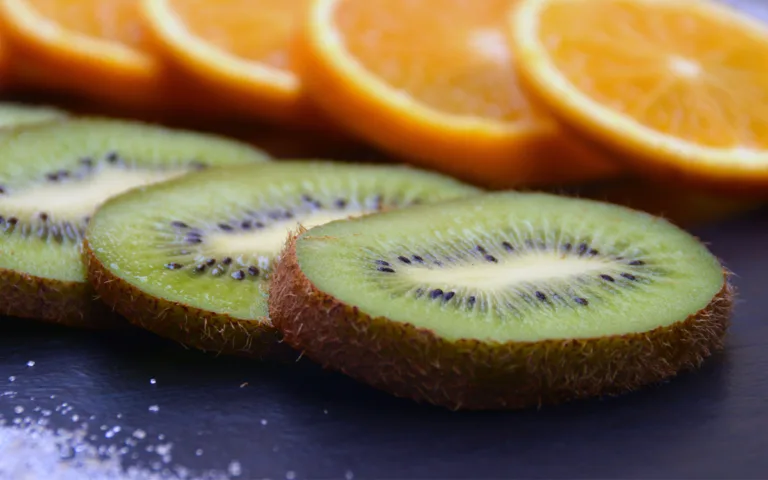 A table displays a kiwi and oranges, highlighting kiwi's higher vitamin C content and its numerous health benefits.