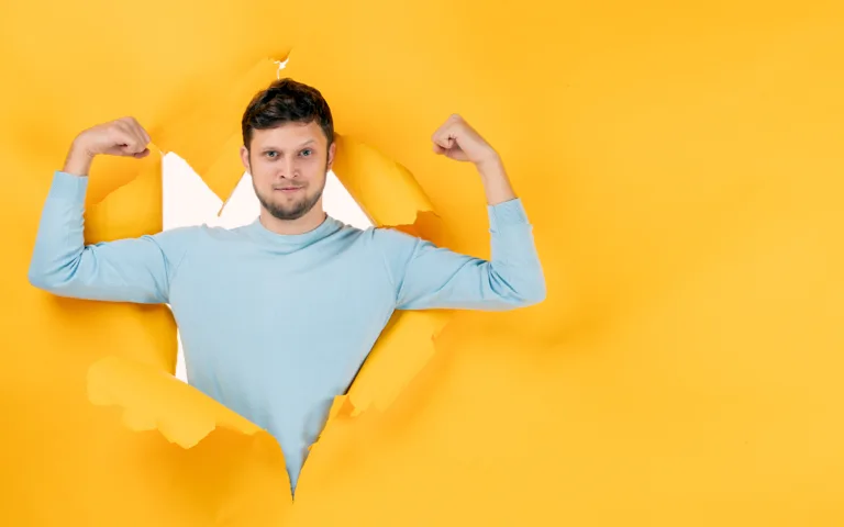 A man stands in a hole cut out of yellow paper, symbolizing the importance of maintaining healthy testosterone levels.