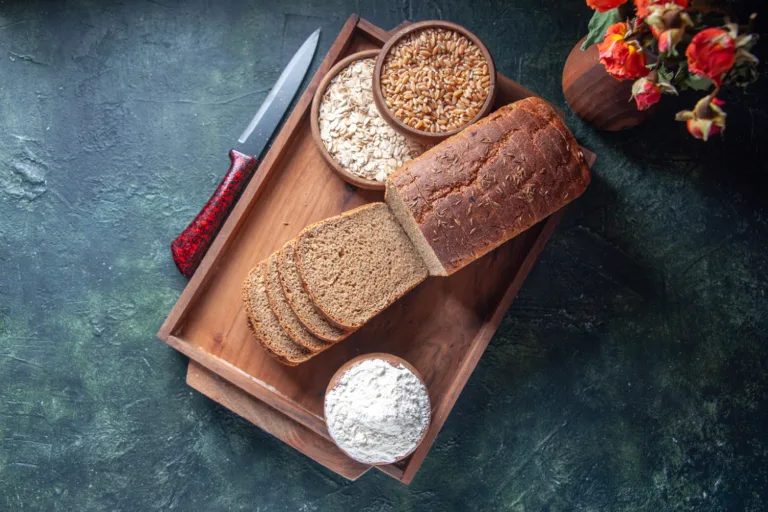 Whole grain bread with oats, wheat, and flour on a wooden tray, illustrating a natural swap from refined grains to whole grains for glucose support