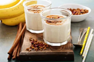 Creamy cinnamon banana smoothie topped with nuts, a healthy drink option that supports balanced glucose levels