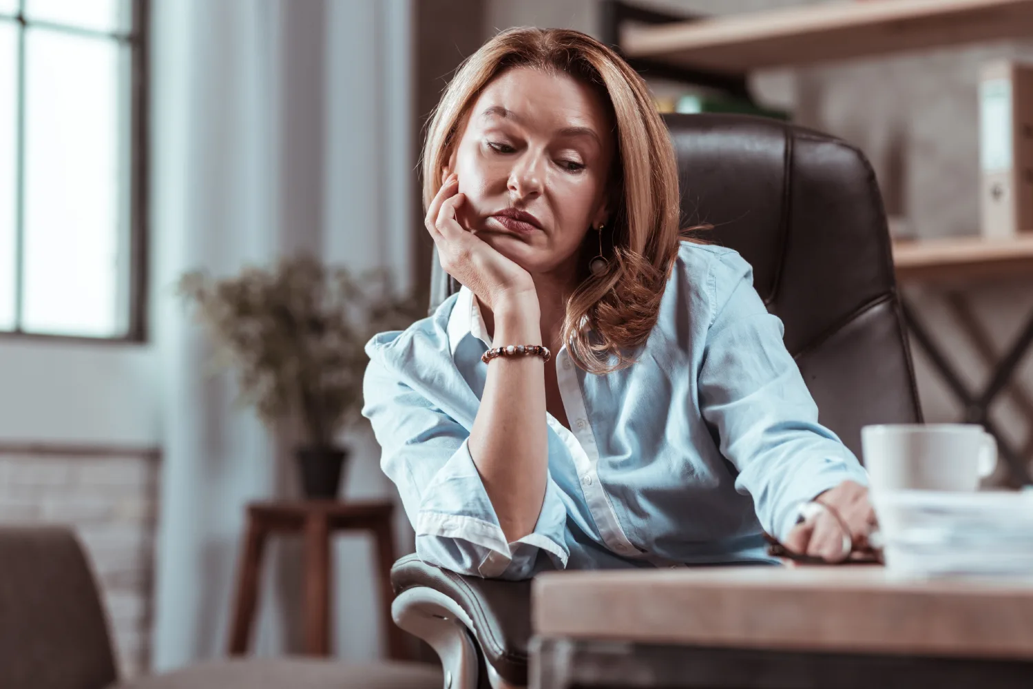 Woman experiencing menopause fatigue and low energy while working, highlighting the need for balanced nutrition