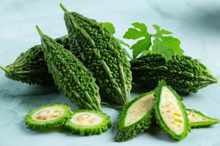 Whole and sliced bitter melon showing inner seeds, representing its nutritional value and use in managing glucose levels naturally.