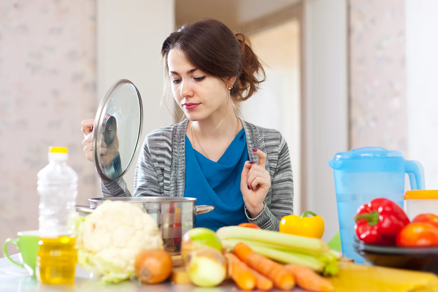Woman preparing healthy vegetables and ingredients in kitchen highlighting the role of nutrition, vitamins and minerals for stronger hair growth