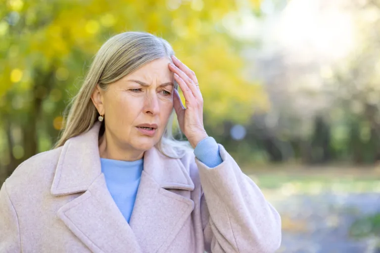 Woman experiencing discomfort and heat outdoors, symbolizing hot flashes and menopause symptoms