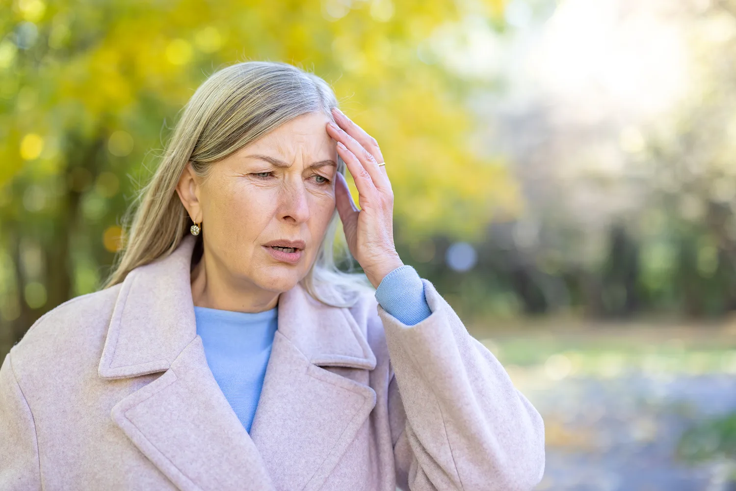 Woman experiencing discomfort and heat outdoors, symbolizing hot flashes and menopause symptoms