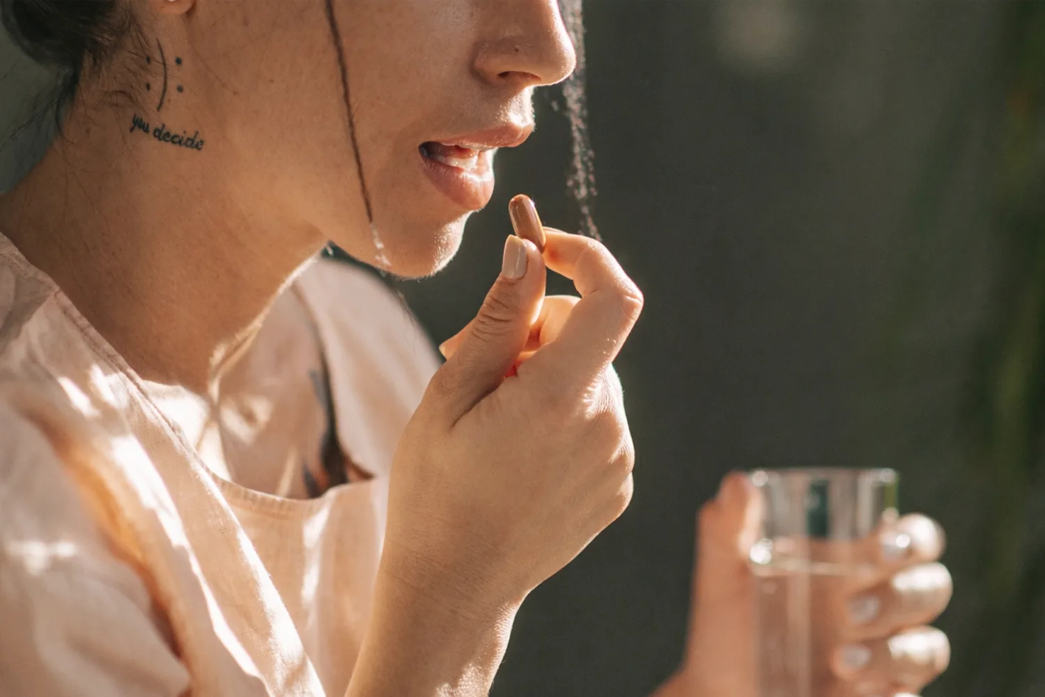 Person taking a supplement capsule with water, illustrating the importance of timing berberine intake for optimal absorption and results